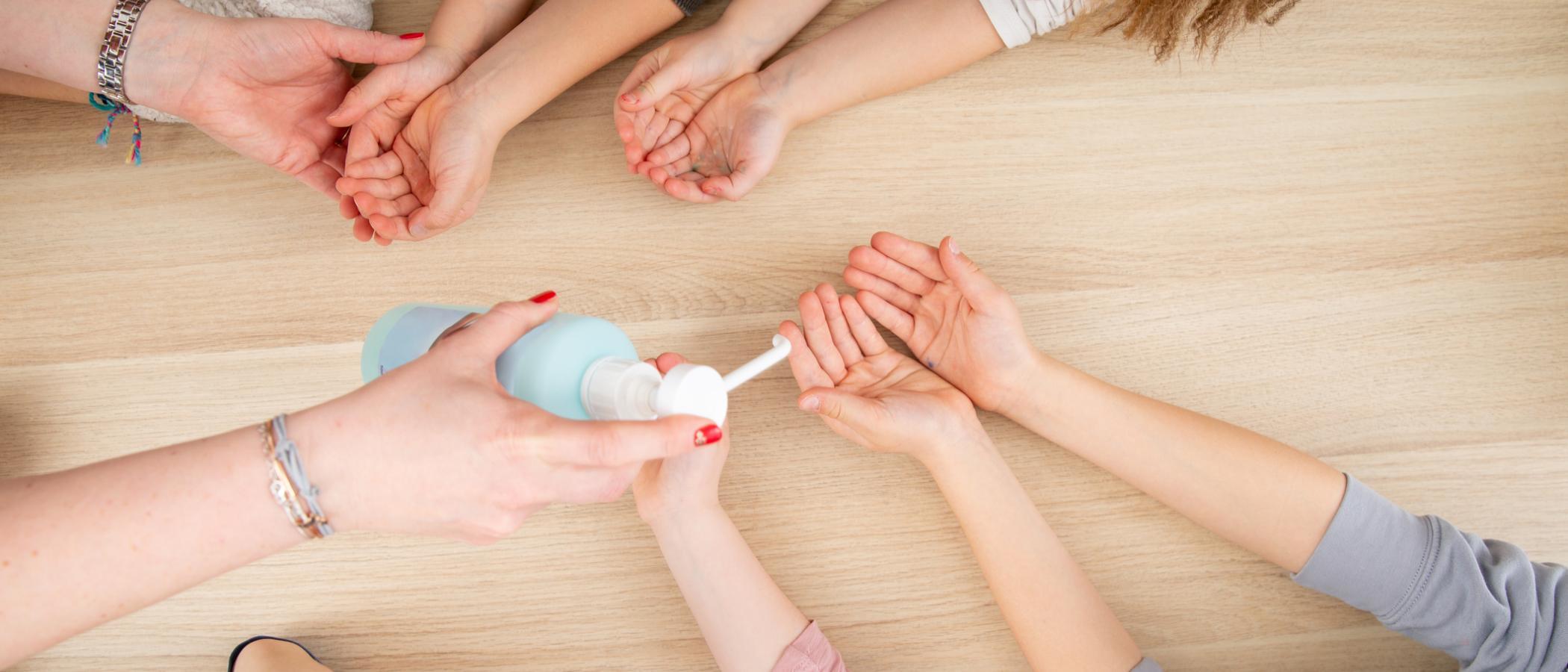 Ein Desinfektionsmittel wird auf viele Kinderhände verteilt